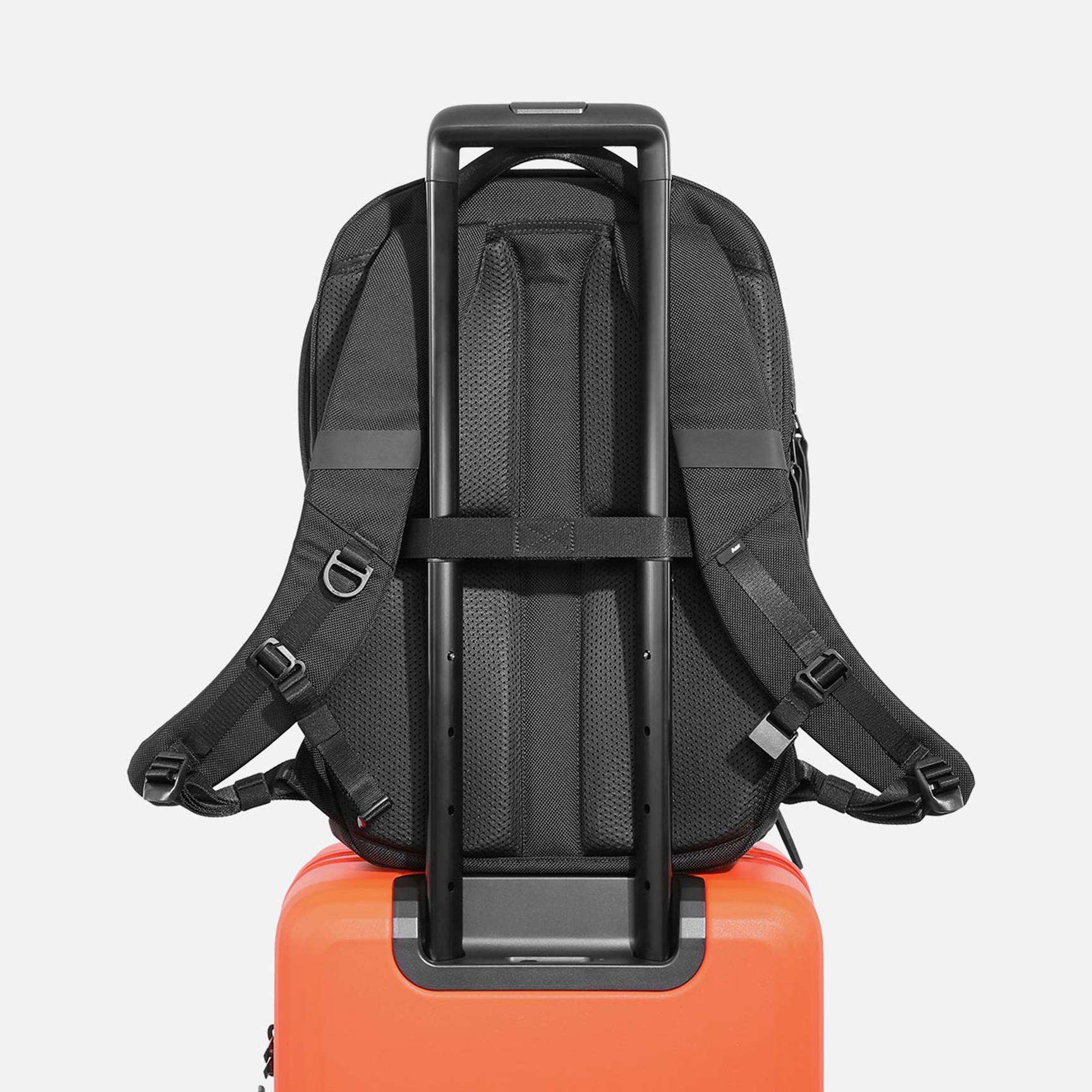Back side of black business laptop backpack with luggage trolley strap, breathable padded back panel for business travel airport trip