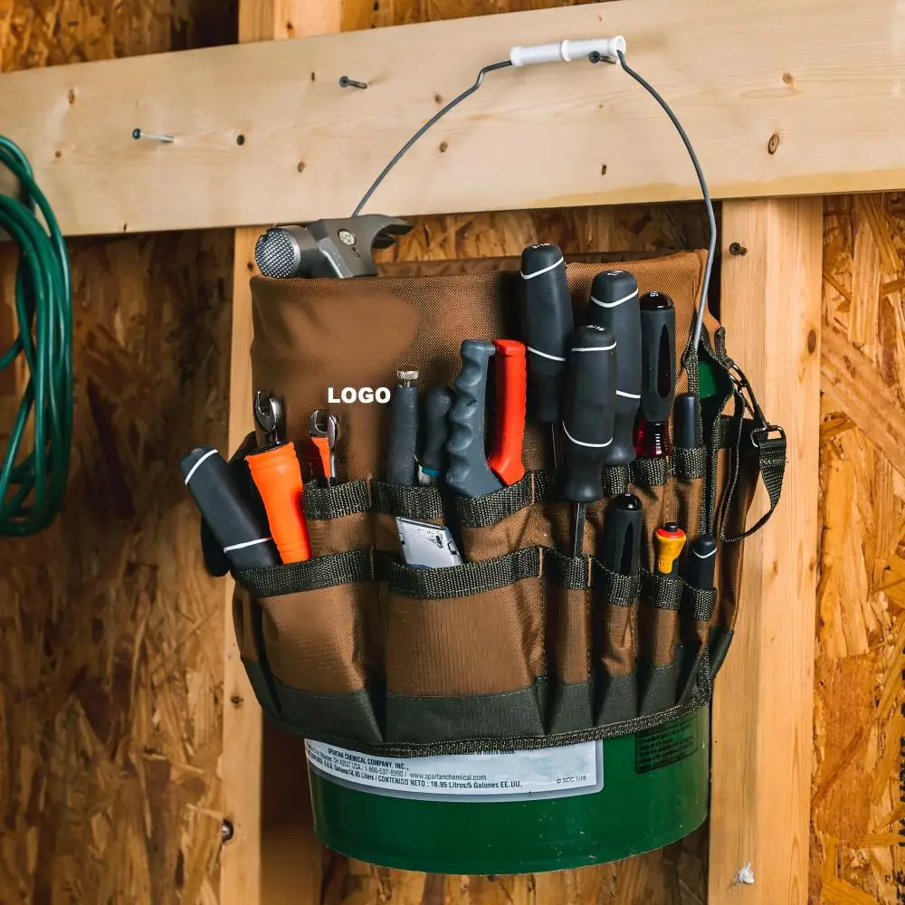 Brown 600D polyester heavy duty 5 gallon bucket tool bag caddy hanging on workshop wall, multi‑pocket hardware tool organizer for carpenter
