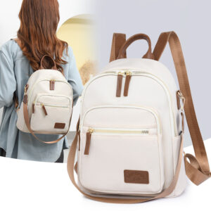Women's beige nylon mini backpack on model, lightweight commuter daypack with brown leather trim